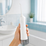Irrigador dental Oria en la mano en el bano